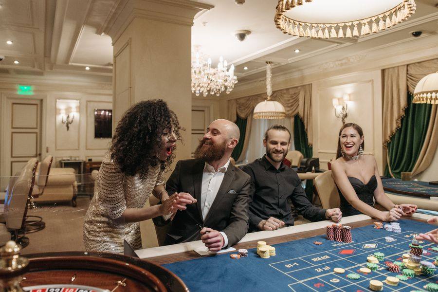 Sekelompok teman bermain kartu bersama di meja poker