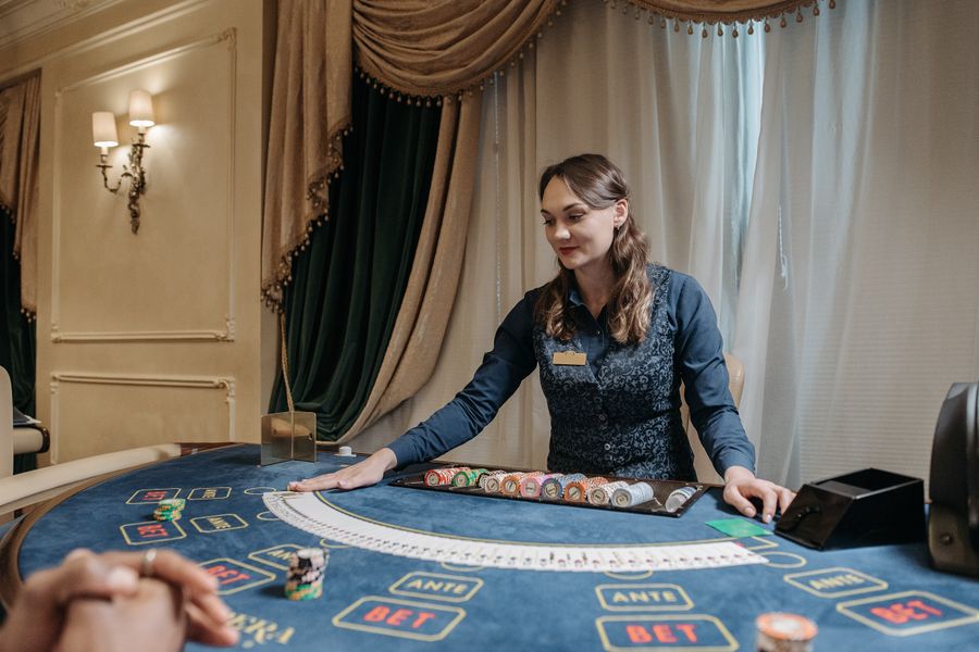 Dealer kasino menyusun kartu dan chip di atas meja hijau